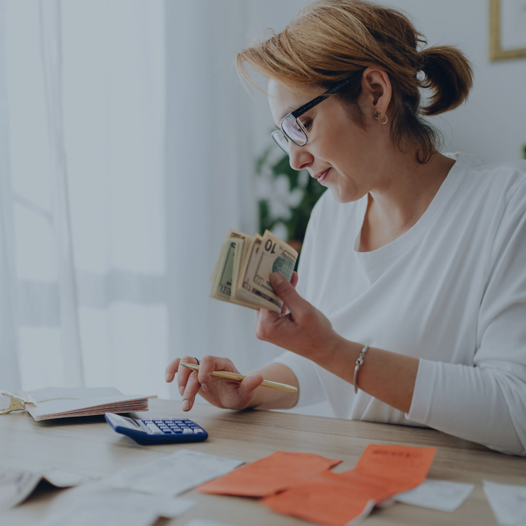 woman holding money reviewing finances